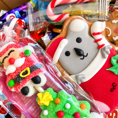 A close-up of assorted festive packaged candies and cookies, including a gingerbread cookie.
